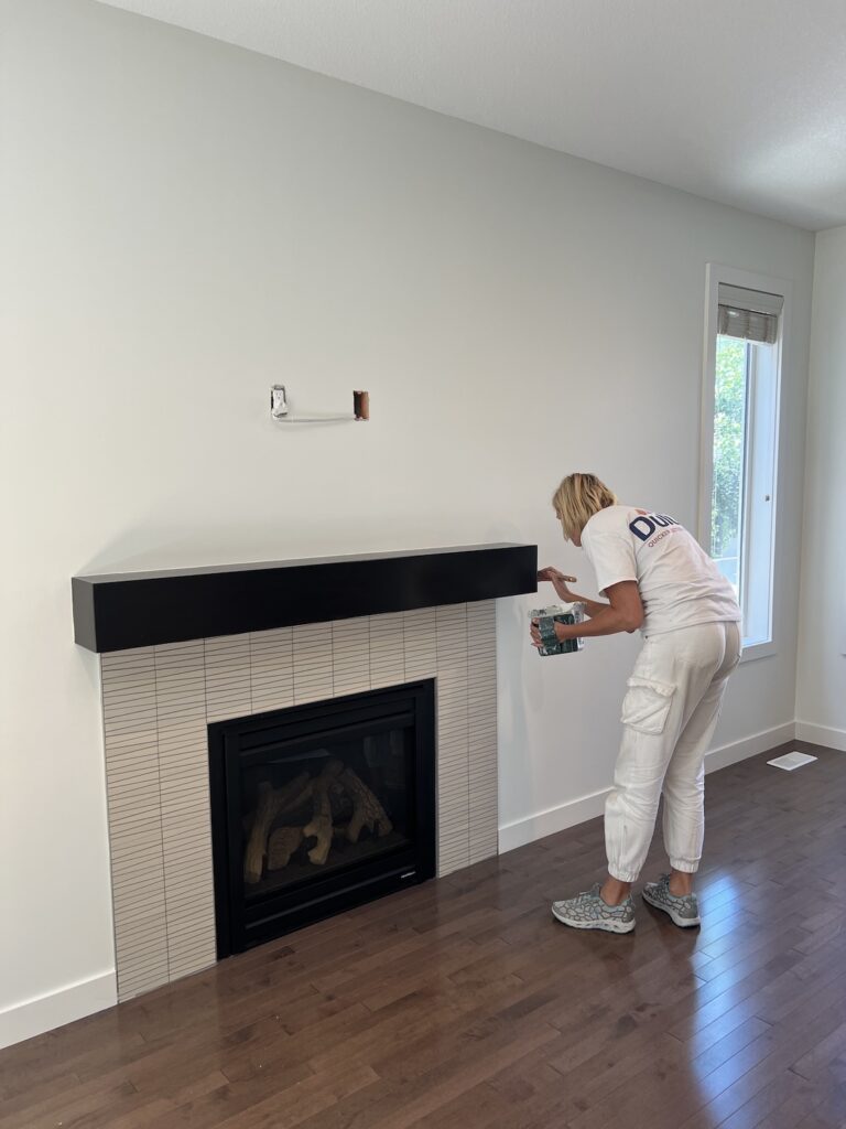 Professional painters applying fresh white paint to a modern living room in Edmonton.