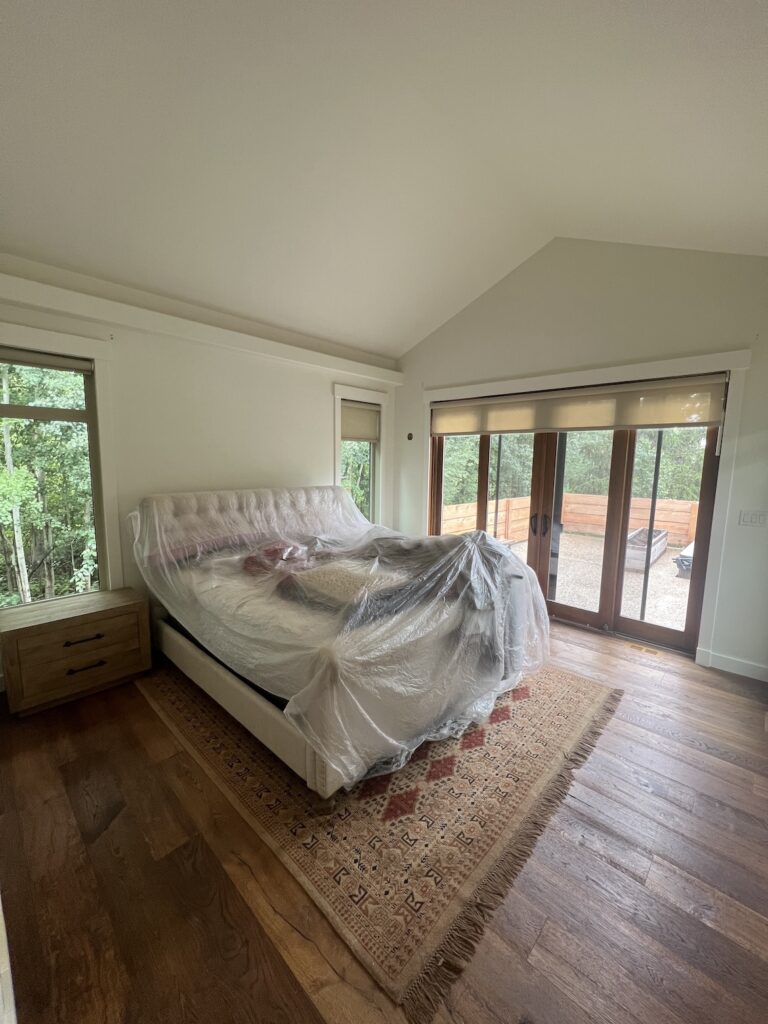 Professional painters applying fresh white paint to a modern living room in Edmonton.