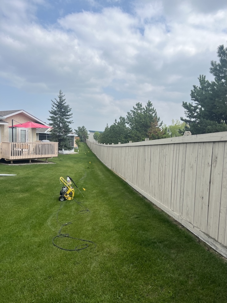 Freshly painted wooden fence with a smooth finish in Edmonton