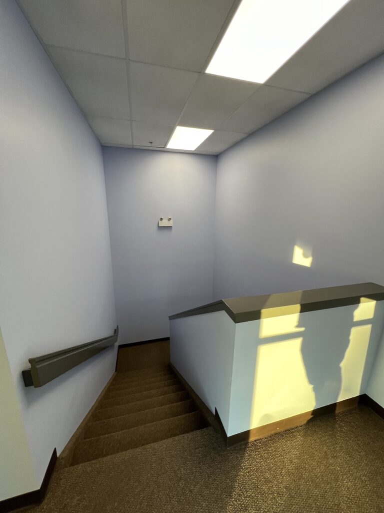 Repainting a commercial office building with modern gray tones for a refreshed look.