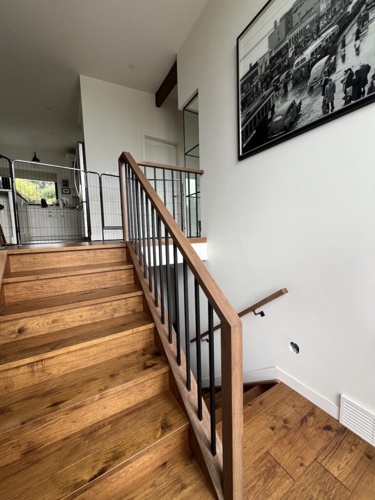 Professional painters applying fresh white paint to a modern living room in Edmonton.